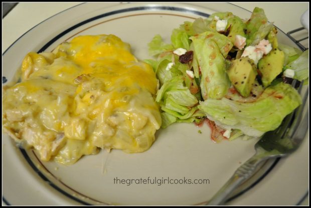 Layered chicken enchilada casserole served with side salad.