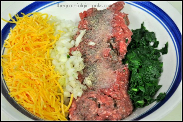 Hamburger meat, cheese, onion and spinach in a bowl.