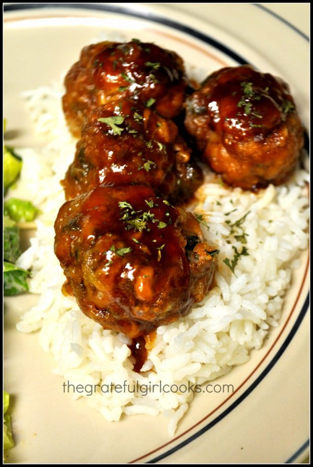 Glazed meatballs are served on top of cooked rice.