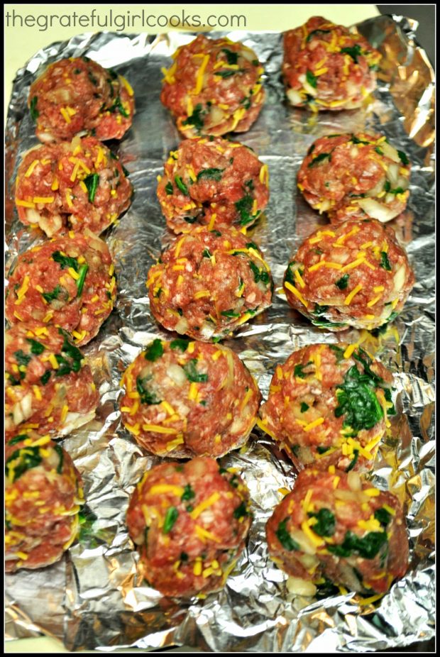 Meatballs are shaped and rest on aluminum foil.