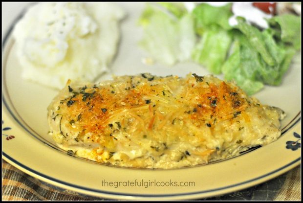 Baked poultry on beige plate with potatoes and salad