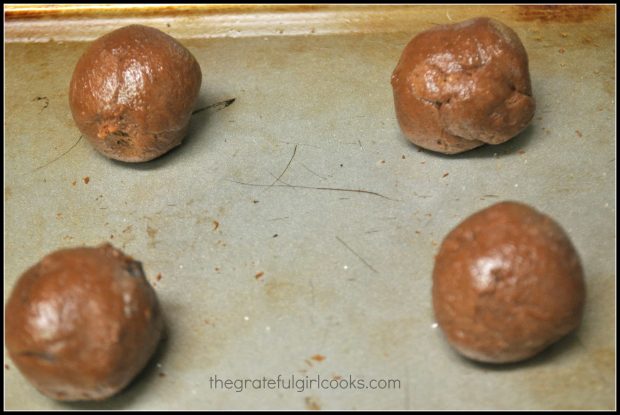 The dough for the chocolate crinkle cookies is rolled into small balls before baking.