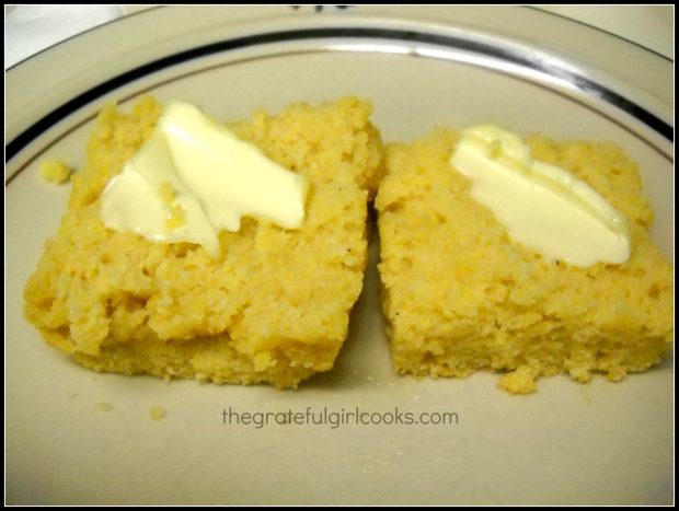 Cornbread is cut in half, and topped with butter for eating.