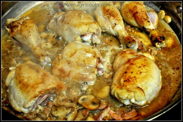 Chicken, onions, garlic are added back into coq au vin sauce.