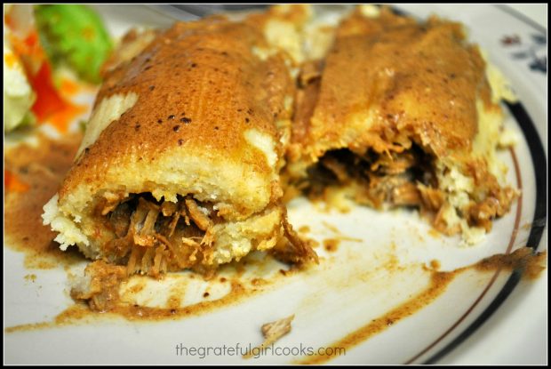 Shredded pork tamales are served with chile sauce on top