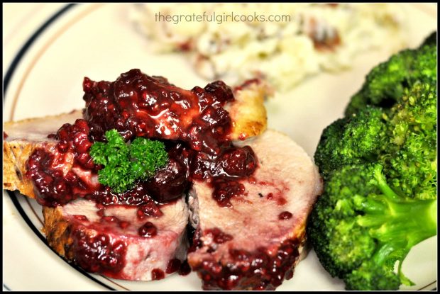 Slices of pork tenderloin with sauce served on plate, with broccoli.