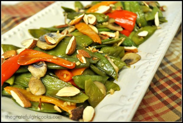 Sugar snap pea stir fry, served on a white platter, is ready to enjoy!
