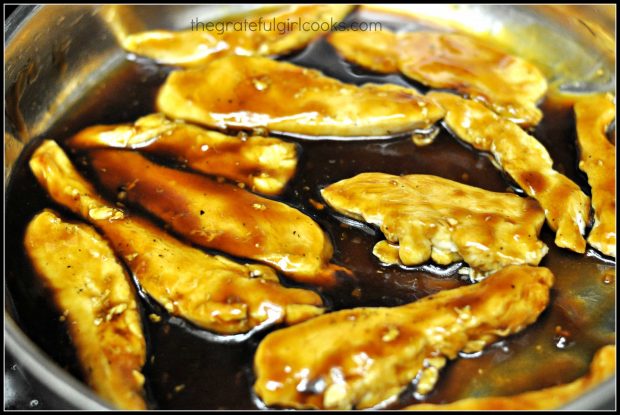 Teriyaki glaze is added to the skillet full of cooked chicken strips.