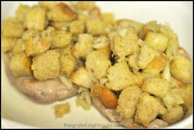 Stuffing is placed on top of browned pork chops before baking.