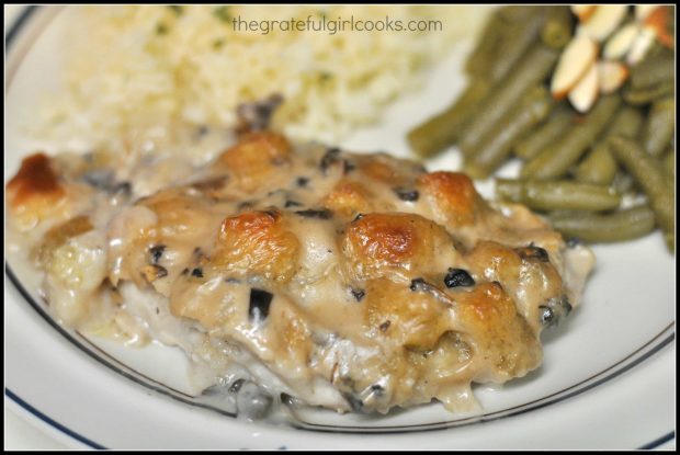 Baked pork chops with stuffing on plate with green beans and rice on the side.