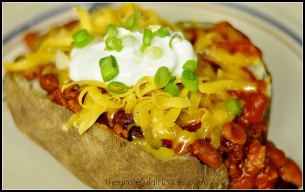 Chili cheese stuffed spud, topped with sour cream, grated cheese & scallions.
