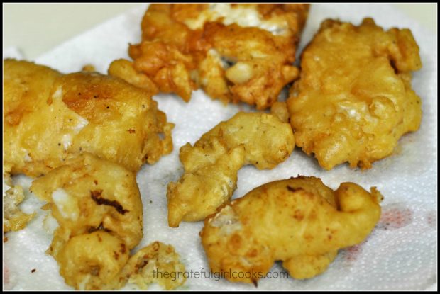 Beer battered fish drains on paper towel after cooking