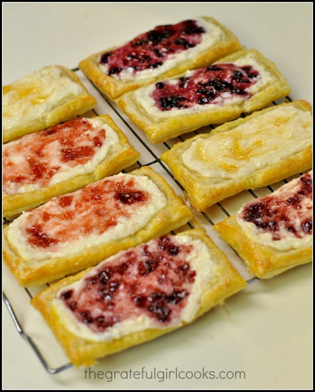 Eight Fruit and Cheese Danish Pastries cool on a wire rack after baking. 