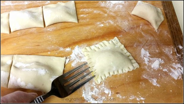 Each of the raviolis is crimped on the edges with a fork.