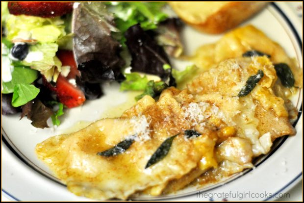 Butternut Squash Ravioli with Browned Butter Sage Sauce on plate with a green salad.