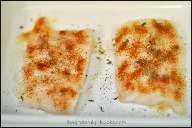 Cod fillets are seasoned with spices before baking.