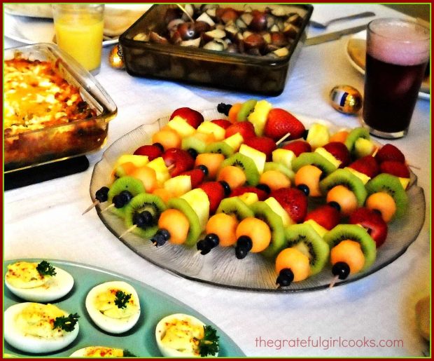 Fruit kabobs, being served at a brunch.