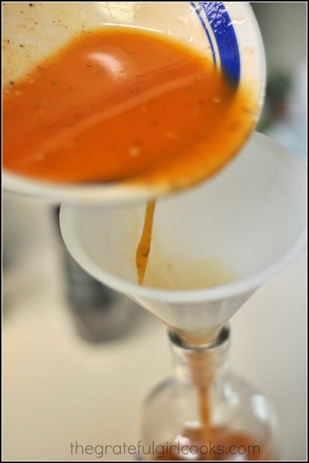 Pour the salad dressing into bottle using a funnel.