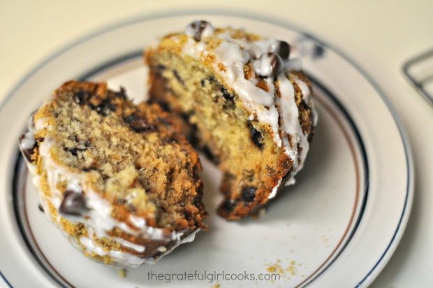 A chocolate chip banana muffin, sliced in half, on a plate.