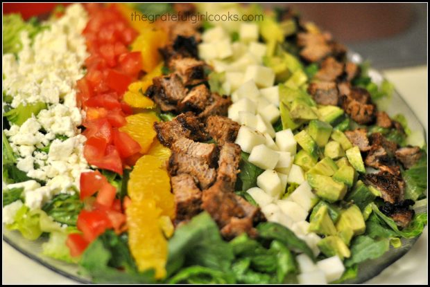 Ingredients for Southwestern cobb salad are placed in rows on Romaine lettuce before serving.