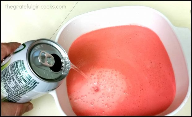 A can of 7-Up is added to the jello mixture in a dish.
