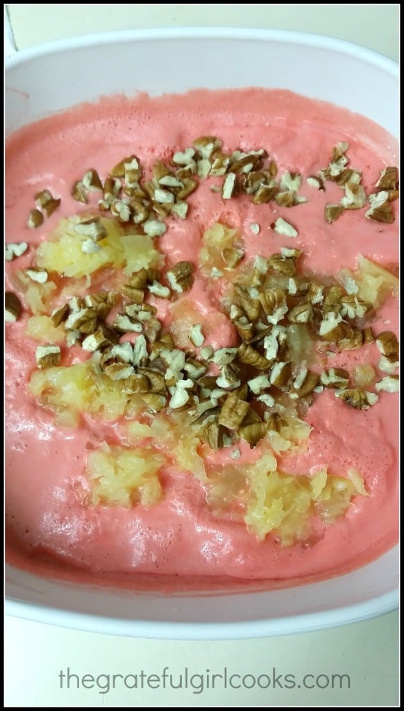 Crushed pineapple and pecans are added to the partially firm jello salad.