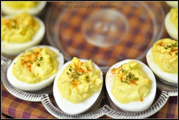 Creamy deviled eggs with paprika and parsley garnish on platter