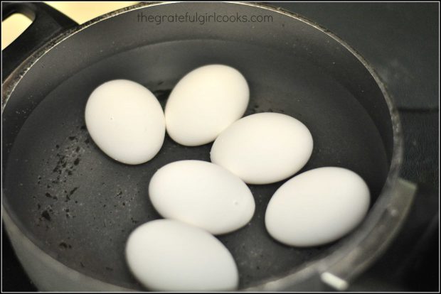 6 eggs cooking in water in saucepan