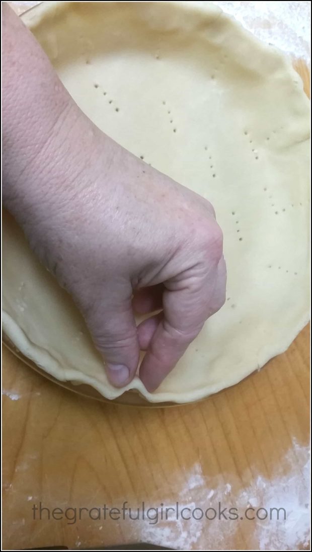 Crimping the crust to shape it for the pie.
