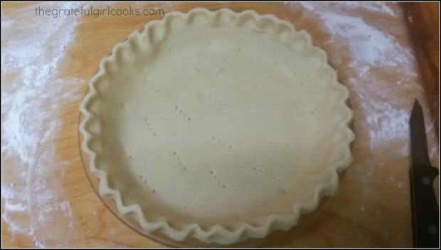 Dough for pie is put into pie plate, crust is formed, and dough is pricked with fork.