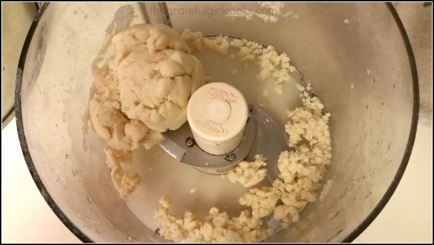 Pie crust dough is processed until it comes together in a ball.