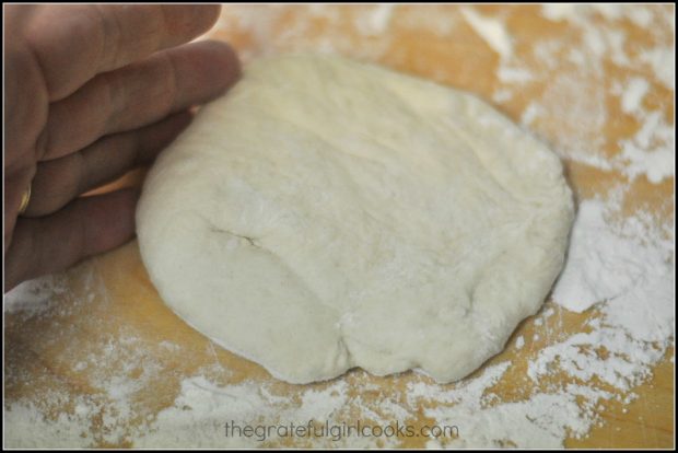 The dough is punched to deflate it after rising, and placed on flour covered work surface.