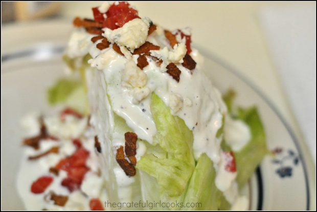 Homemade bleu cheese dressing is drizzled on on a BLT Wedge Salad.