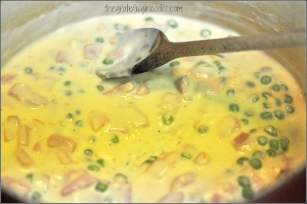 Frozen peas are added to the hot cheese sauce.