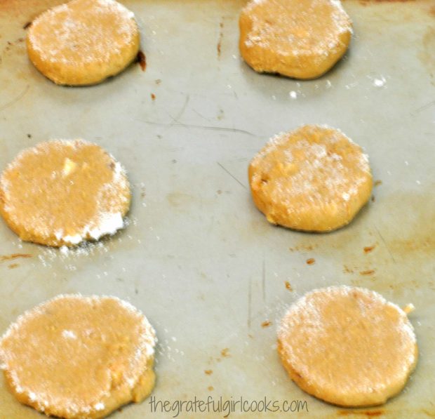 Flattened, sugar topped butter pecan crisps are ready to bake in oven.