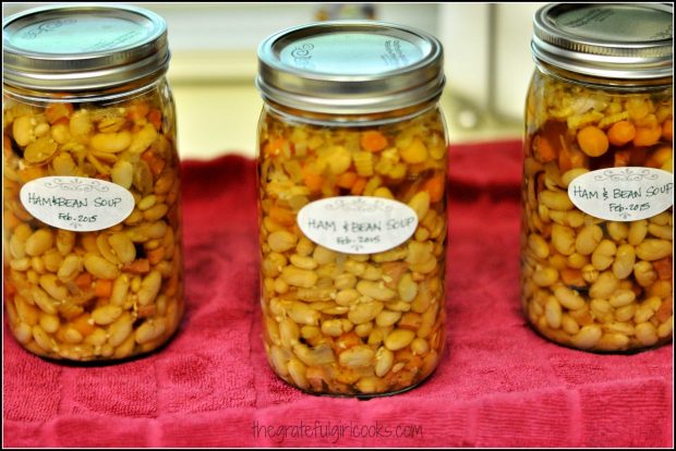 3 jars of canned ham and bean soup on red towel