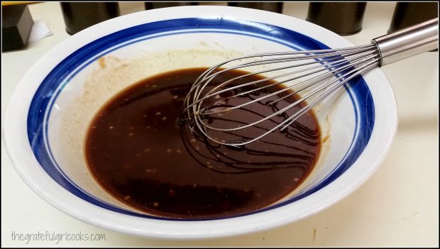 Hawaiian Huli Huli Chicken marinade is whisked to blend ingredients in bowl.