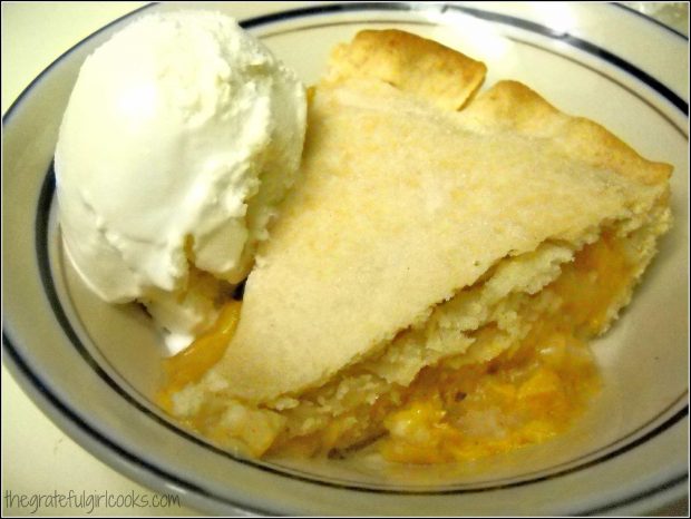 A slice of homemade peach pie is delicious, served a la mode!