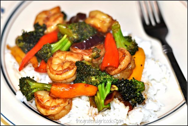 Stir-fried Asian glazed shrimp and veggies, served on a bed of white rice.