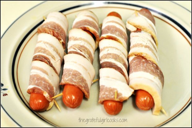 Four all beef weiners wrapped with bacon strip and secured with toothpicks