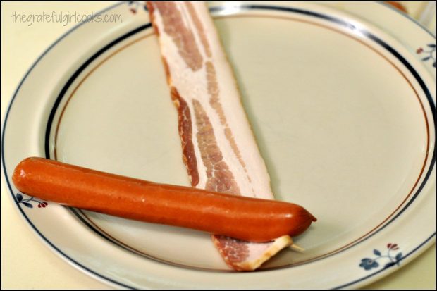 Wrapping a hot dog weiner with raw bacon