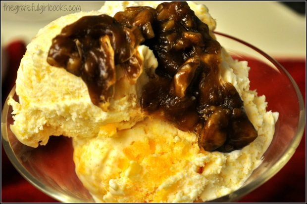 Homemade Peach Ice Cream topped with a praline sauce, in a glass dish.