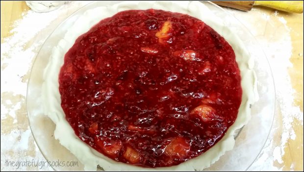 Raspberry-peach melba pie filling added into to pie crust.