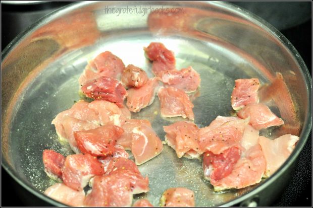 Pork cubes for pork paprikash, cooking in oil in silver skillet