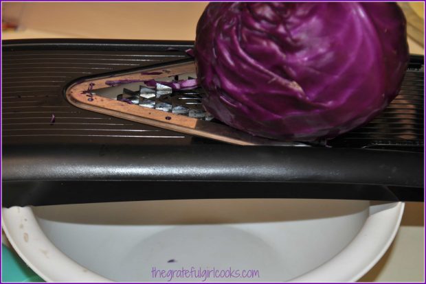 The purple cabbage is shredded on a mandoline or box grater.
