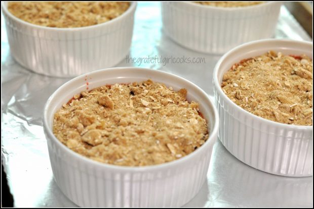 Crumb topping on top of strawberry cobbler ramekins.