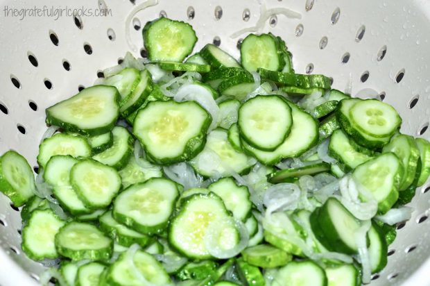 Cucumbers and onions (for pickles) are rinsed and drained in colander