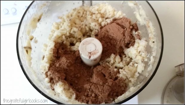Cocoa powder is added to the frozen bananas in the food processor.