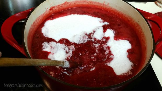 Granulated sugar is added to fruit in pan when making jam.