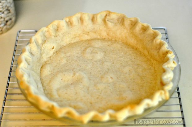 Baked pie crust cooling on wire rack, ready to make strawberry pie.